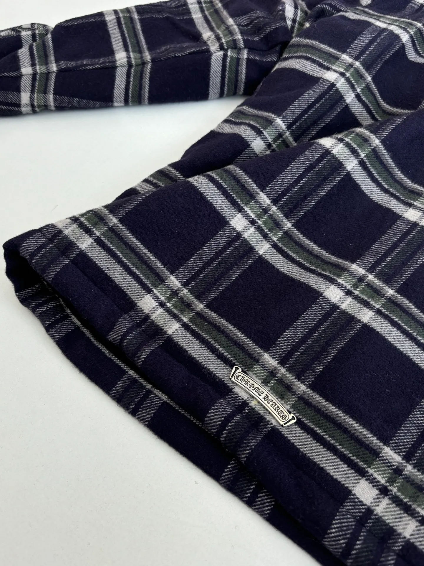 P670 Chrome Heart*/Chrome Heart Contrast Plaid Lapel Shirt Jacket. The fabric is made of 100% cotton fabric to create a navy blue main tone plaid. The rough plaid lines blend into the brand's iconic Gothic rebellious gene. The stiff cotton material supports the street silhouette, and the plush fabric inside adds softness and warmth. The collision of cold silver hardware and soft and warm inner wear is the dark aesthetic of Chrome Hearts' "symbiosis of hard core and gentleness". The autumn and winter layering has its own rock and roll accent.  Size：S/M/L/XL